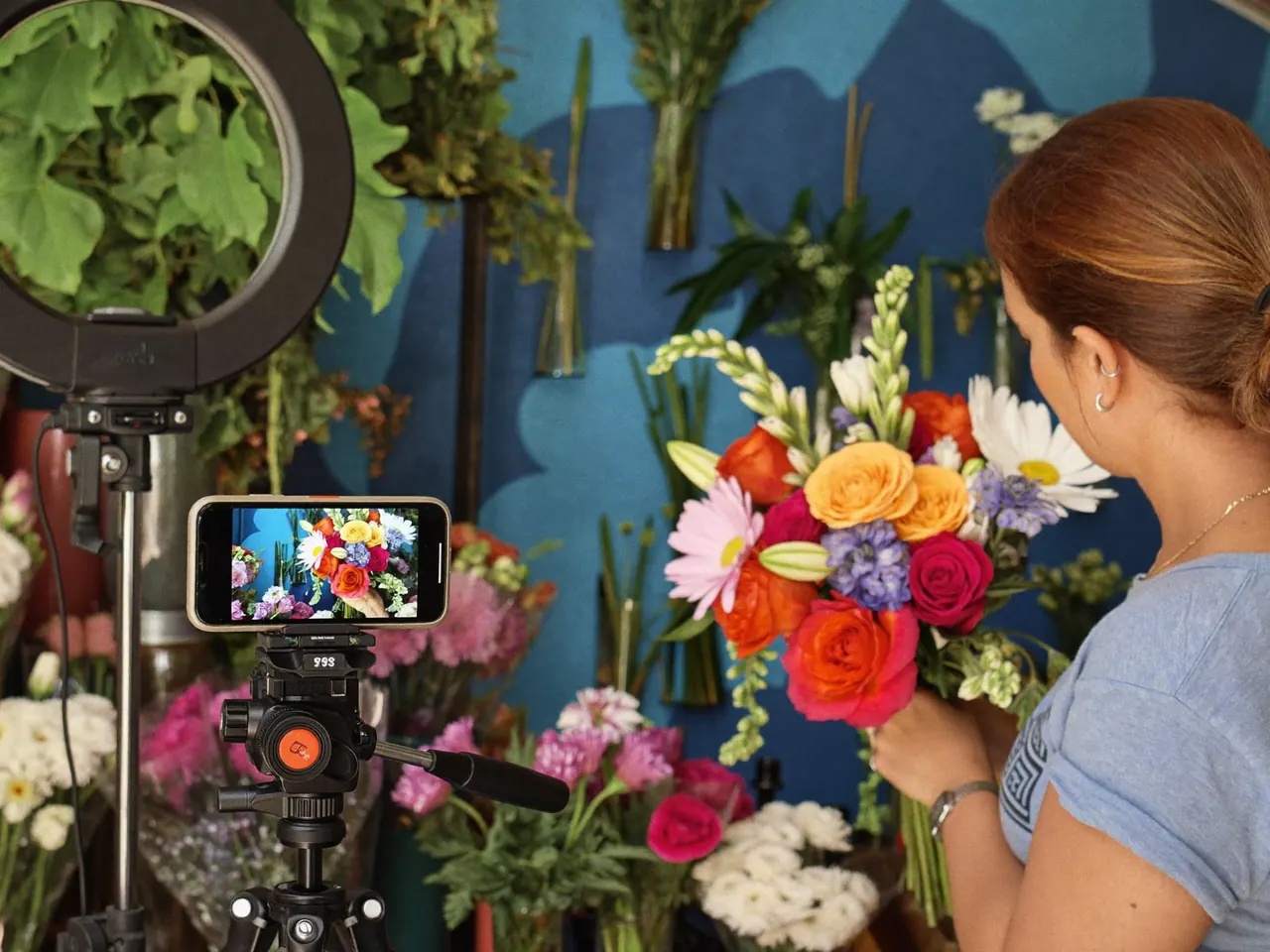 Florist filming a bouquet with a phone on a tripod for a social media post